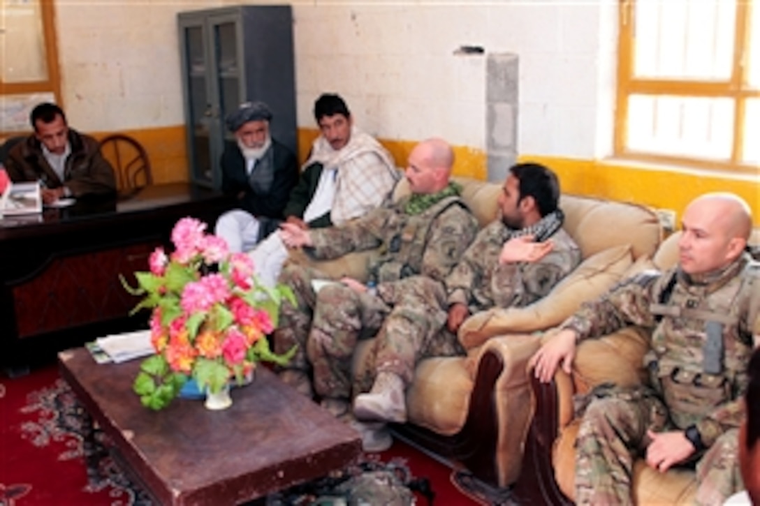 Coalition force members talk with Lalmohmmad Azizi, left, provincial director of counternatics, during a meeting in Farah, Afghanistan, Dec. 15, 2012.