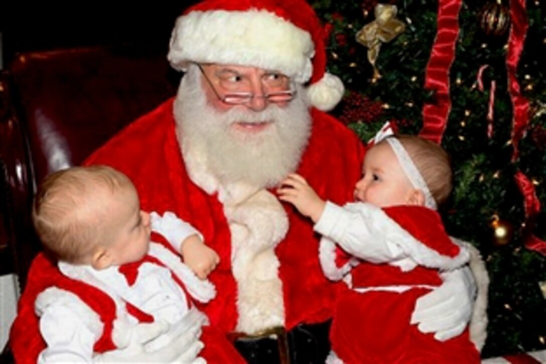 Two small children visit with Santa Claus at the U.S. Army Garrison Baden-Württemberg's final Holiday Magic event in Heidelberg, Germany, Dec. 16, 2012. The annual celebration featured live music, a Christmas market, train rides and a community tree-lighting ceremony.