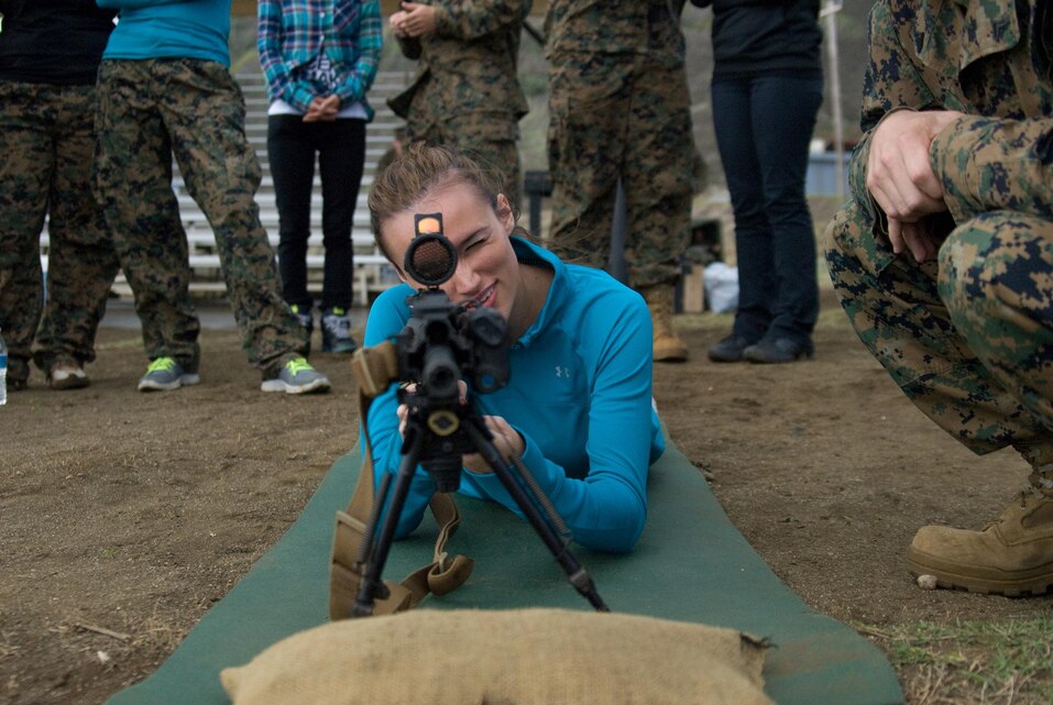 MARINE CORPS BASE HAWAII - Fellow spouses look on as Danielle Buzzard looks through the sight of an unloaded rifle at Range Training Facility Kaneohe Bay during Jane Wayne Day, Dec. 19, 2012. Spouses and girlfriends of 3rd Battalion, 3rd Marine Regiment service members visited the range and Boondocker Training Area. The ladies learned how to shoot and execute proper techniques to compete an obstacle course. (Official U.S. Marine Corps photo by Kristen Wong)