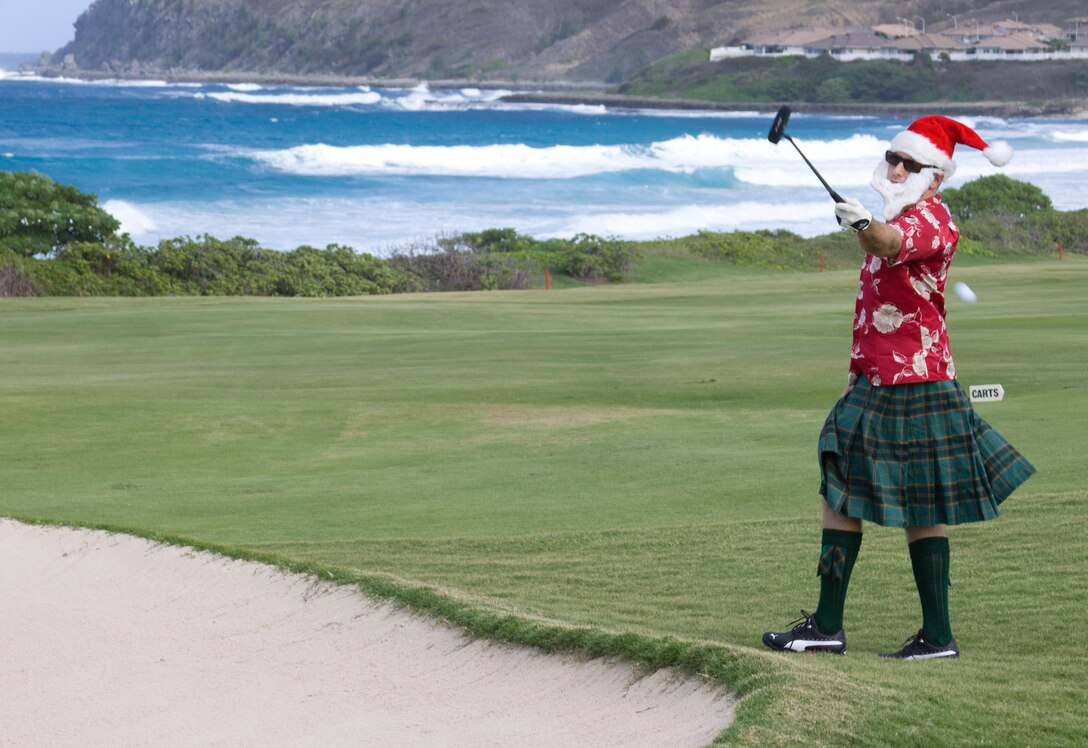MARINE CORPS BASE HAWAII - Matt C. Somerville, festively dressed as a Scottish Santa, passes a golf ball from a sandpit to a teammate during the Commander’s Cup Golf Classic at the Kaneohe Klipper Golf Course Complex, Dec. 14. “I’m playing with the Christmas spirit at heart and I want to pass the spirit on to others,” Somerville said. “I’m enjoying myself and with the help of my elves [fellow teammates], our team should do quite well.” (Official U.S. Marine Corps photo by Cpl. Vanessa M. American Horse)