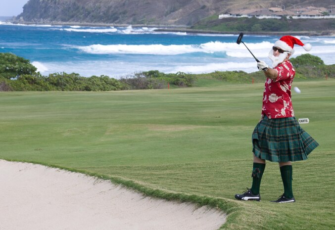 MARINE CORPS BASE HAWAII - Matt C. Somerville, festively dressed as a Scottish Santa, passes a golf ball from a sandpit to a teammate during the Commander’s Cup Golf Classic at the Kaneohe Klipper Golf Course Complex, Dec. 14. “I’m playing with the Christmas spirit at heart and I want to pass the spirit on to others,” Somerville said. “I’m enjoying myself and with the help of my elves [fellow teammates], our team should do quite well.” (Official U.S. Marine Corps photo by Cpl. Vanessa M. American Horse)