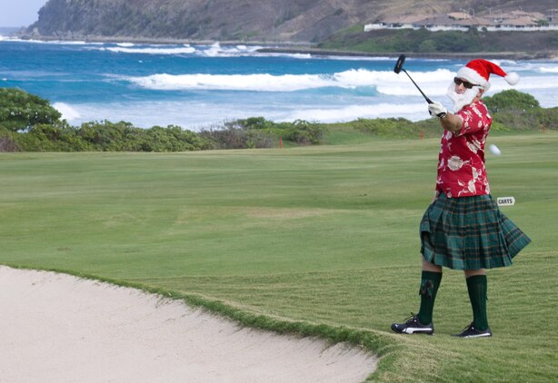 MARINE CORPS BASE HAWAII - Matt C. Somerville, festively dressed as a Scottish Santa, passes a golf ball from a sandpit to a teammate during the Commander’s Cup Golf Classic at the Kaneohe Klipper Golf Course Complex, Dec. 14. “I’m playing with the Christmas spirit at heart and I want to pass the spirit on to others,” Somerville said. “I’m enjoying myself and with the help of my elves [fellow teammates], our team should do quite well.” (Official U.S. Marine Corps photo by Cpl. Vanessa M. American Horse)