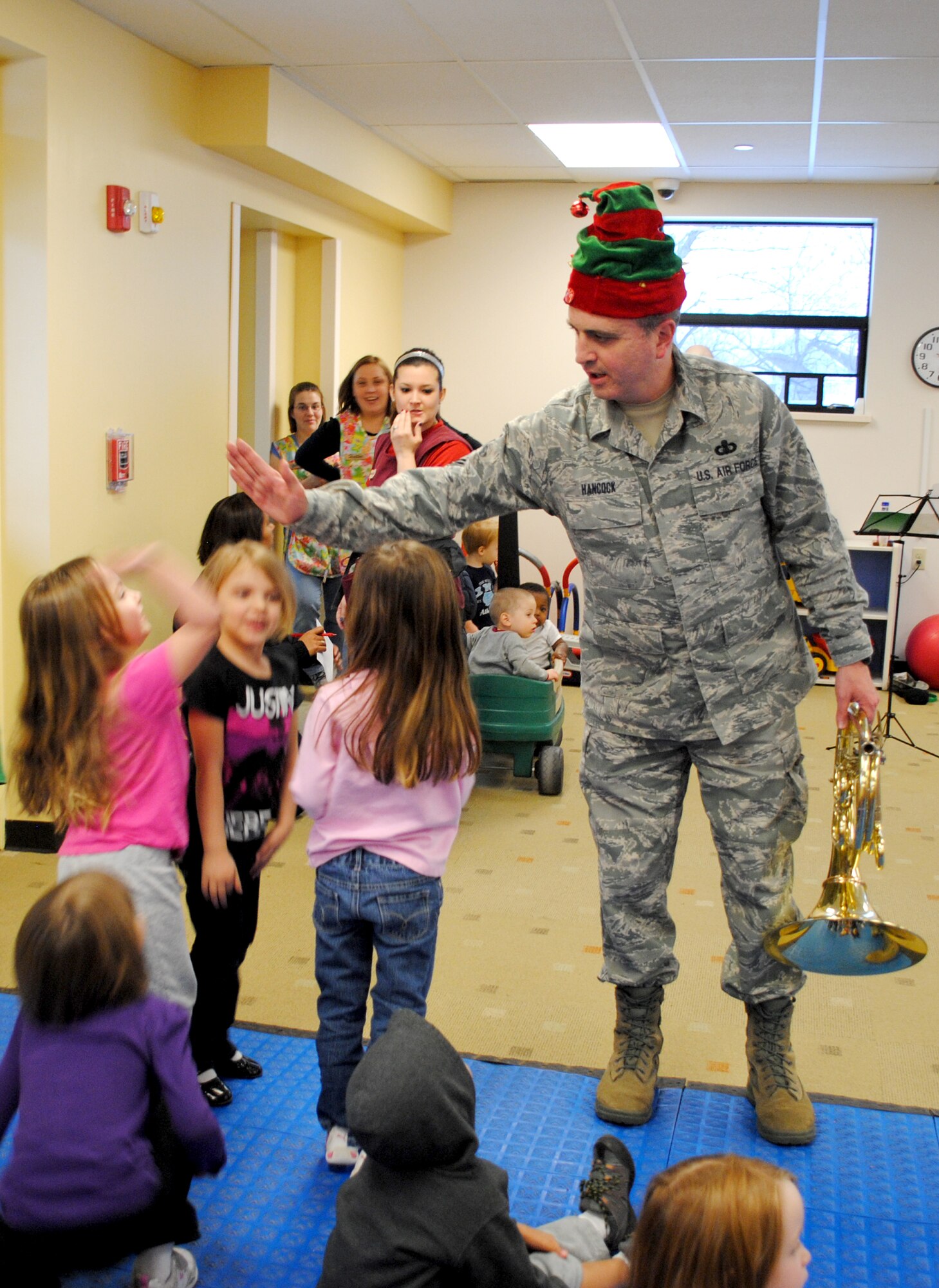 Master Sgt. Hughey L. Hancock, gets another high-five from a military youngster who wanted to thank members of the United States Air Force Heartland of America Band, who played several child-holiday songs, Dec. 18, 2012, at the Child Development Center on Grand Forks Air Force Base, N.D. The band toured the base for two consecutive days, performing holiday songs at 22 locations around the base. (U.S. Air Force photo/Senior Airman Luis Loza Gutierrez)