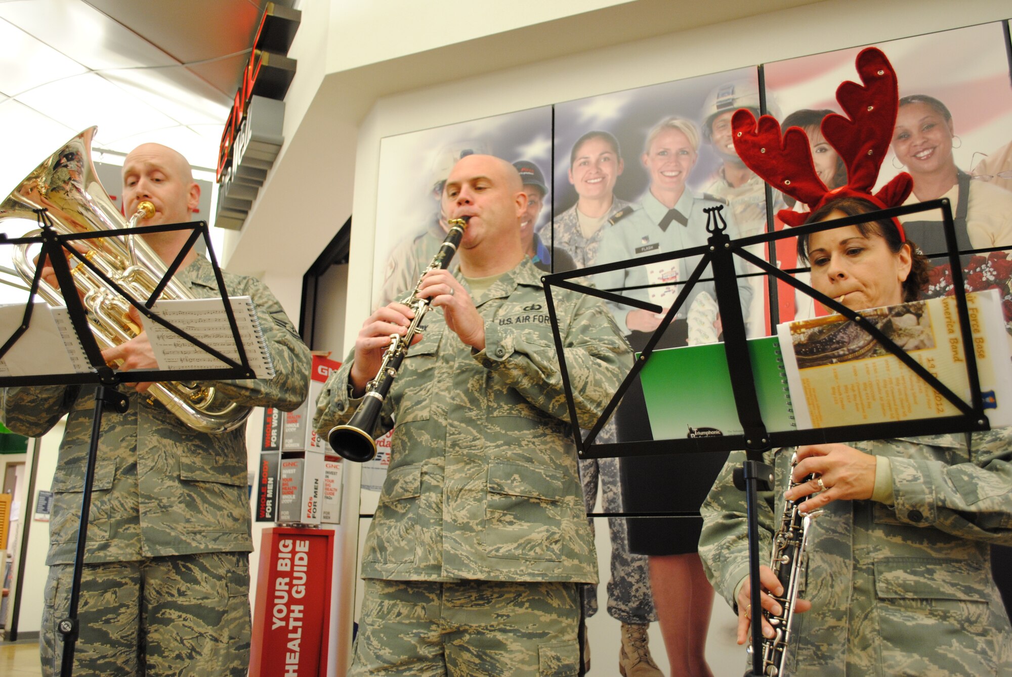 Master Sgt. Matthew Dunsmore, Tech Sgt. Richard LaCroix, and 1st Sgt. Nancy Montera, members of the United States Air Force Heartland of America Band, perform “Carol of the Bells” Dec. 18, 2012, at the Exchange on Grand Forks Air Force Base, N.D. The band toured the base for two consecutive days, performing holiday songs at 22 locations around the base. (U.S. Air Force photo/Senior Airman Luis Loza Gutierrez)