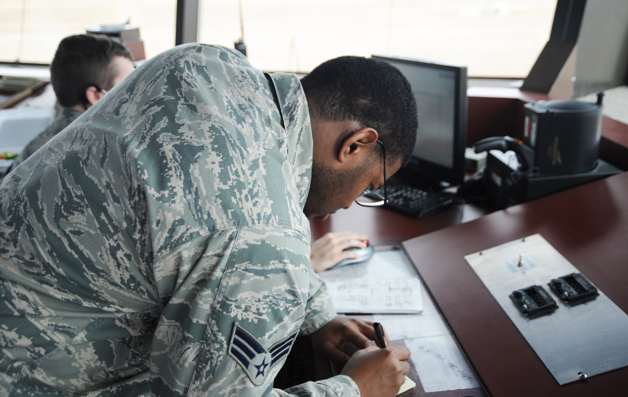 U. S. Air Force Senior Airman Cordney Stewart, 366th Operations Support Squadron air traffic controller, writes down information while working ground control Dec. 13, 2012, at Mountain Home Air Force Base, Idaho. Stewart communicates with ground support personnel and pilots in case of an emergency. (U. S. Air Force photo/Senior Airman Benjamin Sutton)  