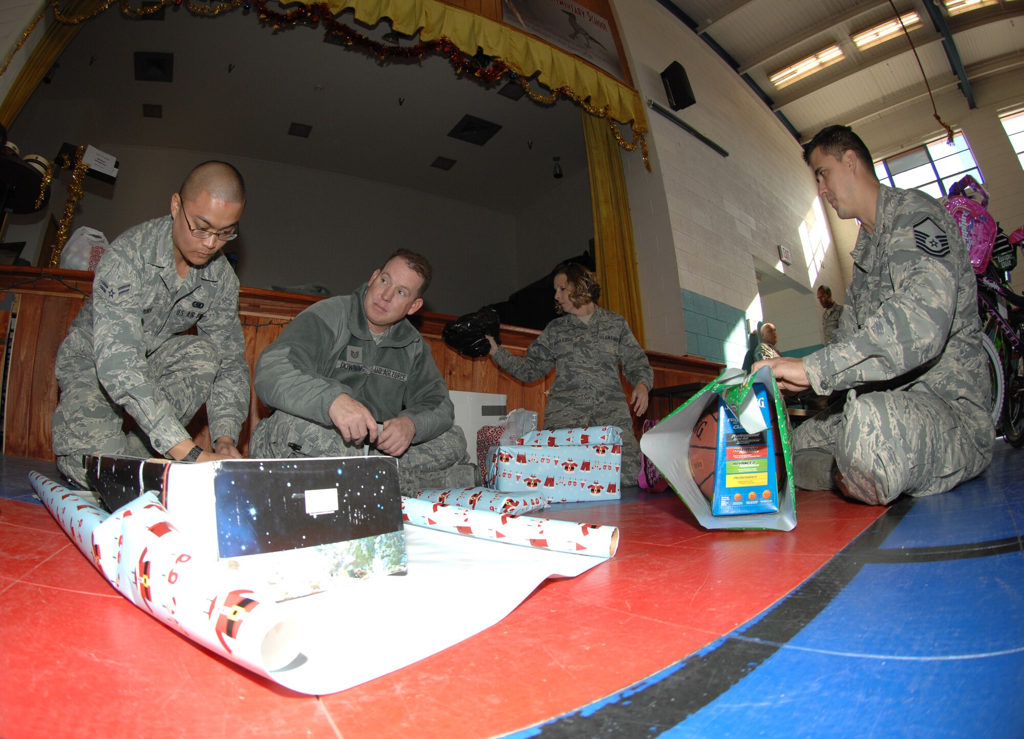 Airmen from Davis-Monthan wrap presents for the children of Indian Oasis Elementary School for the Santa’s in Blue event Dec. 20 at Sells, Ariz. All of the presents were already wrapped, but in transit had ripped and needed to be rewrapped.  (U.S. Air Force photo by Senior Airman Michael Washburn/Released)