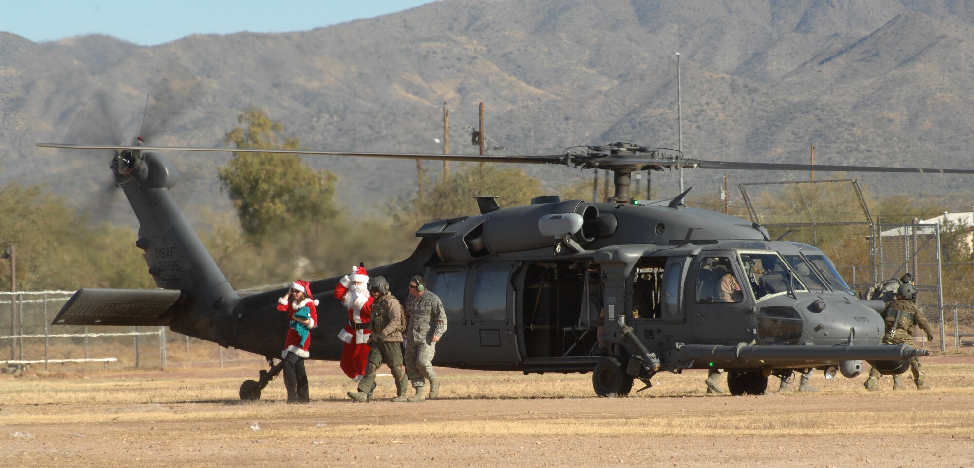 Santa and Mrs. Claus arrive at Indian Oasis Elementary School by helicopter for the Santa’s in Blue event in Sells, Ariz., Dec. 20. Santa and Mrs. Claus landed in the school’s baseball field to children screaming their names. (U.S. Air Force photo by Senior Airman Michael Washburn/Released)