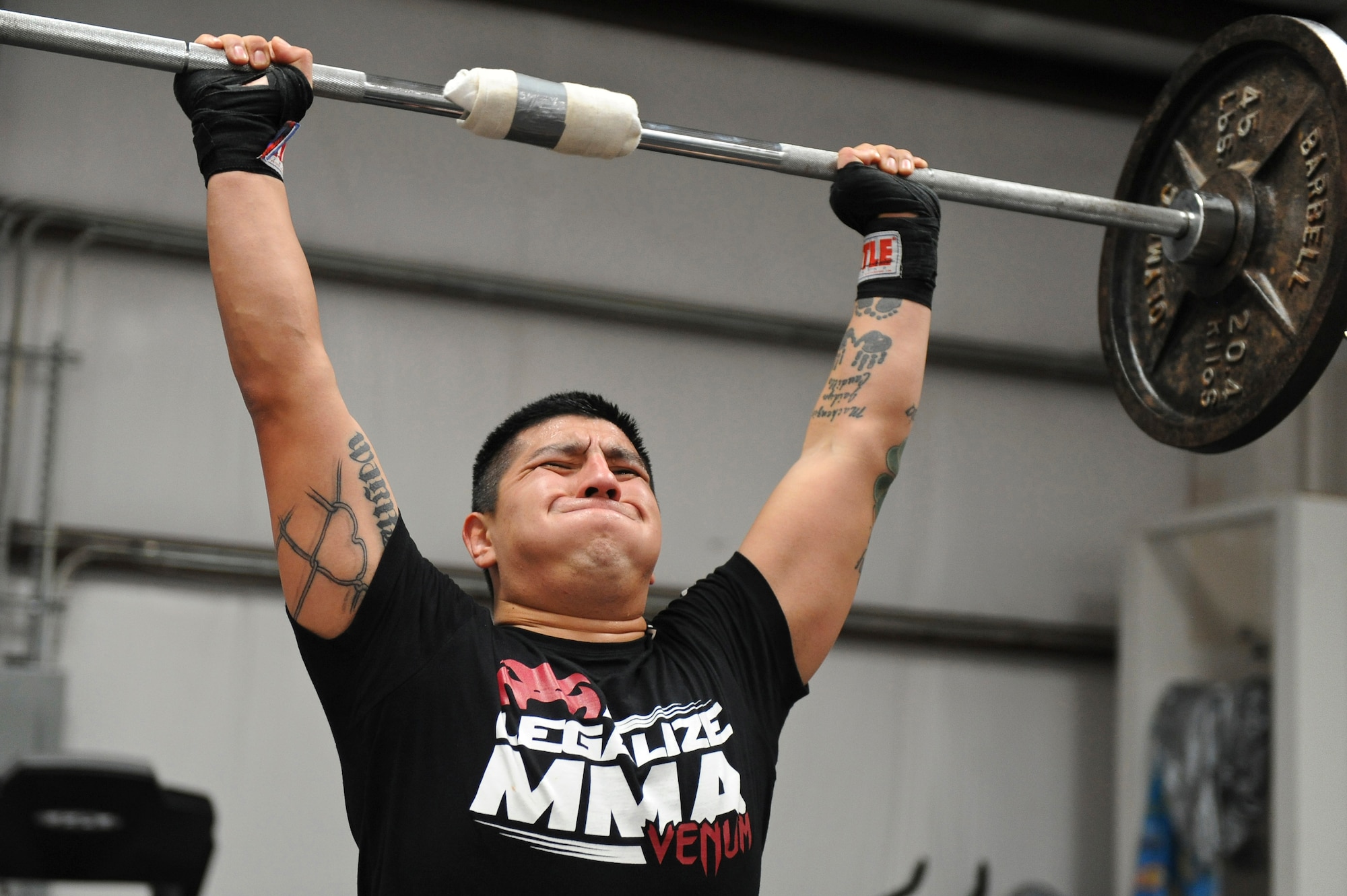 Staff Sgt. Jeremy Caudillo, 2nd Force Support Squadron, lifts weights at a local mixed martial arts gym in Bossier City, La., Dec. 12. Caudillo started competing in local amateur MMA fights after his deployment to Afghanistan. Over the years Caudillo learned kick boxing, Jiu-Jitsu and Muay Thai along with various strength and endurance exercises. Caudillo takes the training he receives at the MMA gym and uses them to help his fellow Airmen stay fit to fight. (U.S. Air Force photo/Senior Airman Micaiah Anthony)