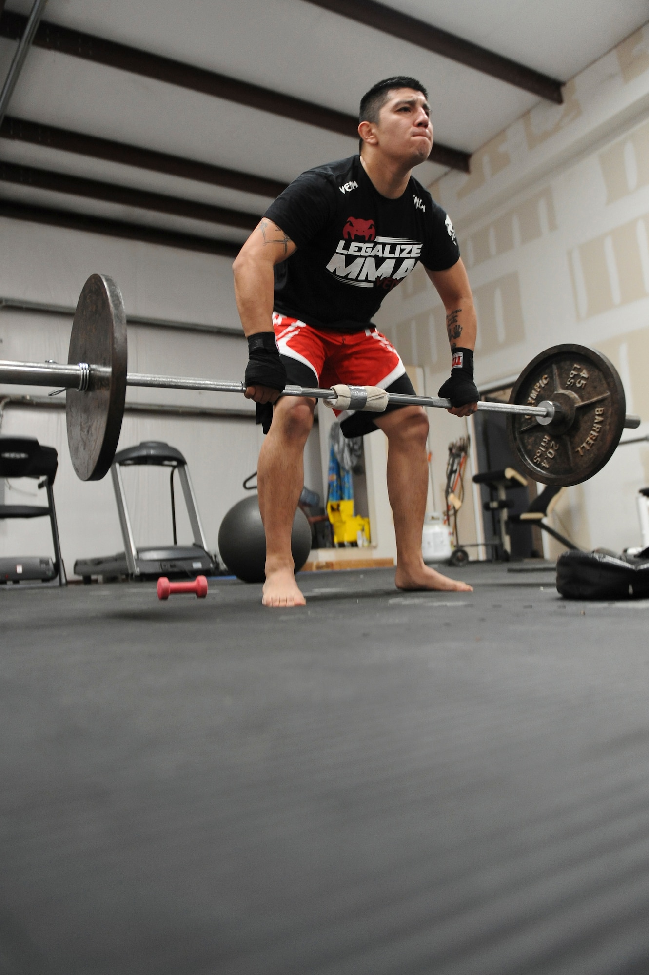 Staff Sgt. Jeremy Caudillo, 2nd Force Support Squadron, lifts weights at a local mixed martial arts gym in Bossier City, La., Dec. 12. Caudillo works at the Fitness Center on Barksdale Air Force Base, La., and often uses exercises he learned from MMA training to help Airmen stay fit to fight.  Caudillo is currently training for his first professional fight in March. (U.S. Air Force photo/Senior Airman Micaiah Anthony)