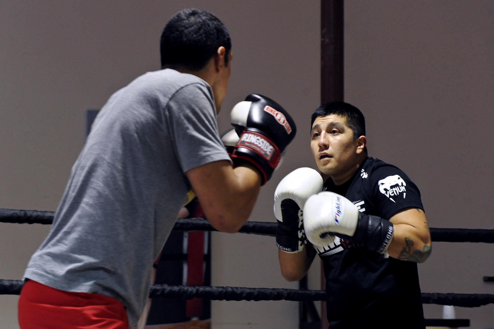 Airman 1st Class Justin Solorio, left, and Staff Sgt. Jeremy Caudillo, 2nd Force Support Squadron, begin their sparring session at a local mixed martial arts gym in Bossier City, La., Dec. 12. The two Airmen work at the Fitness Center on Barksdale Air Force Base, La., and enjoy training and competing in MMA competitions. Caudillo takes some of the exercises he learns from the MMA gym and uses them to help his fellow Airmen stay fit to fight. (U.S. Air Force photo/Senior Airman Micaiah Anthony)