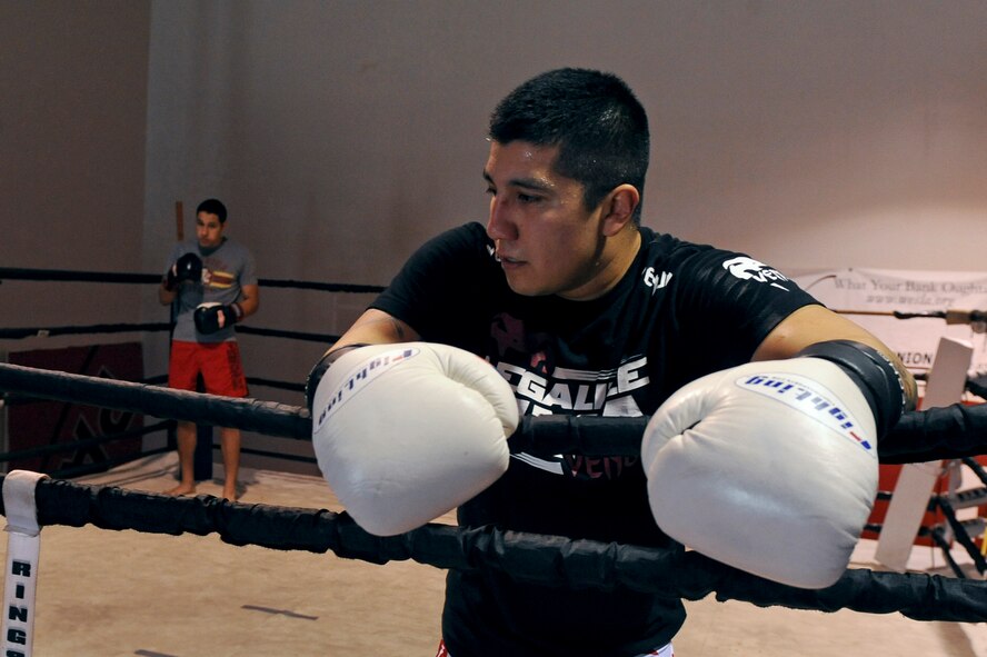 Staff Sgt. Jeremy Caudillo, 2nd Force Support Squadron fitness center supervisor, rests on the ropes after a sparring session as Airman 1st Class Justin Solorio, 2 FSS, waits in his corner at a local mixed martial arts gym in Bossier City, La., Dec. 12.The two Airmen work at the Fitness Center on Barksdale Air Force Base, La., and enjoy training and competing in MMA competitions. Caudillo is currently training for his first professional fight in March. (U.S. Air Force photo/Senior Airman Micaiah Anthony)