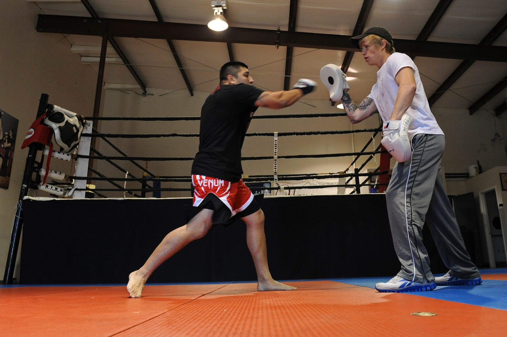 Staff Sgt. Jeremy Caudillo, 2nd Force Support Squadron fitness center supervisor, spars with Russell Biggs, mixed martial arts general manager and trainer, at a local MMA gym in Bossier City, La., Dec. 12. Caudillo is currently training for his first professional MMA fight in March. He began his fighting career as a wrestler in high school and college. Caudillo often uses exercises he learned from MMA training to help Airmen stay fit to fight. (U.S. Air Force photo/Senior Airman Micaiah Anthony)