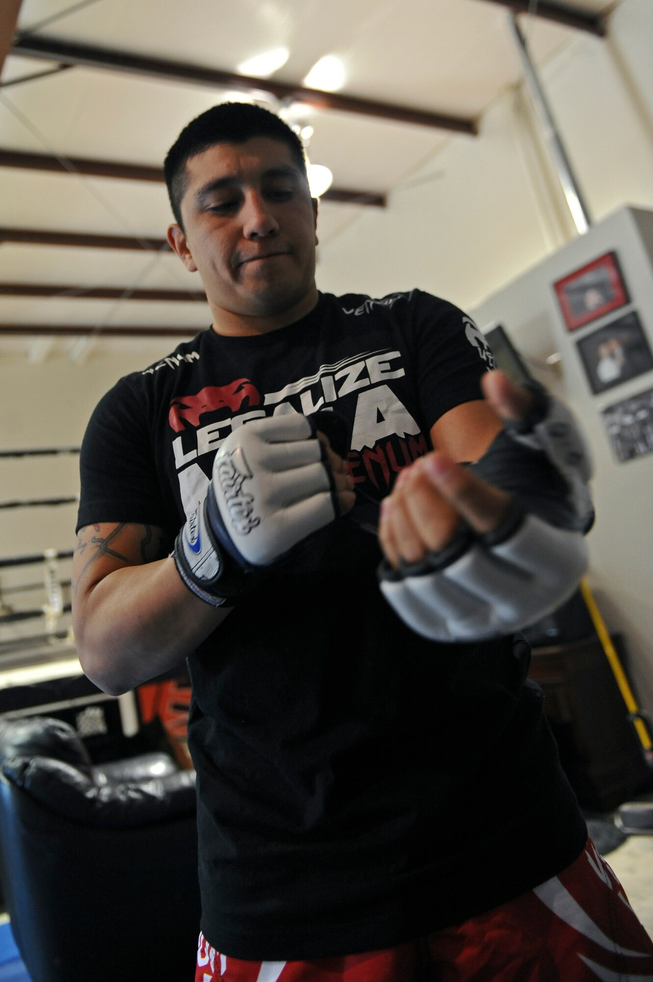 Staff Sgt. Jeremy Caudillo, 2nd Force Support Squadron fitness center supervisor, puts on a pair of mixed martial arts fighting gloves at a local MMA gym in Bossier City, La., Dec. 12. Caudillo is currently training for his first professional MMA fight in March. Caudillo competed in local amateur MMA fights for the past two years. His current record is six wins and three losses. (U.S. Air Force photo/Senior Airman Micaiah Anthony)
