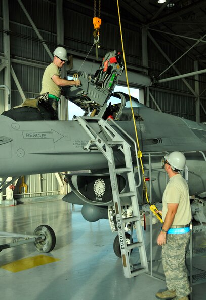 Staff Sgt. Ian Hyatt, 20th Operations Group Detachment 2 Aircrew Egress Systems, and Tech. Sgt. Steven Rosenberg, 482nd Maintenance Squadron Aircrew Egress Systems, perform a seat and canopy removal at Homestead Air Reserve Base, Fla., Dec. 11. (U.S. Air Force photo/Senior Airman Jacob Jimenez)