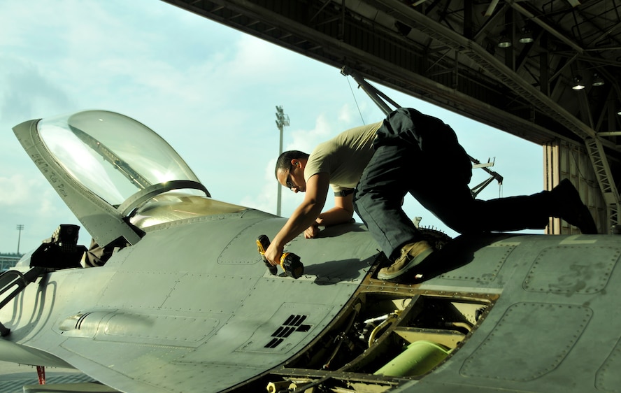 Senior Airman Jose Rocha, 482nd Aircraft Maintenance Squadron crew chief, installs a horseshoe panel on an F-16 at Homestead Air Reserve Base, Fla., Dec. 11. (U.S. Air Force photo/Senior Airman Jacob Jimenez)