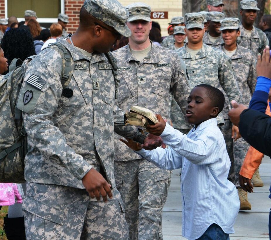 U.S. Army Staff Sgt. William Johnson, a human resources specialist with 3rd Platoon, 510th Human Resources Company, Special Troops Battalion, 7th Sustainment Brigade, receives a last-minute goodie bag before boarding the bus bound for the airport following the 510th HRC deployment ceremony at Fort Eustis, Va., Dec. 8. The Soldiers deployed to Kuwait on a nine-month assignment, where they will perform human resource support as part of the gateway theatre mission. (U.S. Army photo by Sgt. Edwin Rodriguez/Released)
