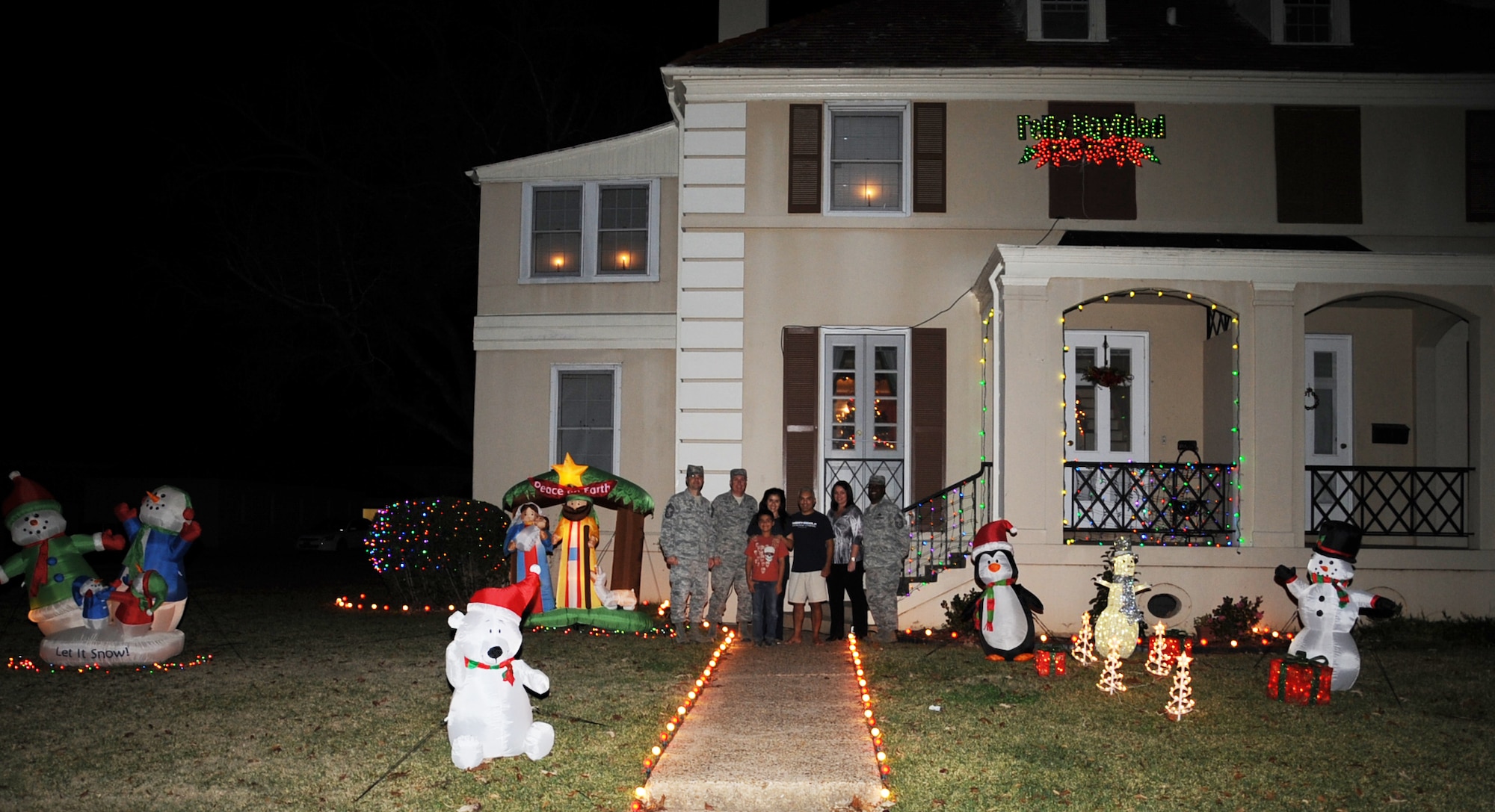 A winner of the holiday lighting contest poses with members of the Barksdale Chief's Group and a representative from the housing office during the Holiday Lights Contest on Barksdale Air Force Base, La., Dec. 18. Four houses were chosen as having the best holiday decorations and were presented with a $100 gift card. (U.S. Air Force photo/Senior Airman Sean Martin)