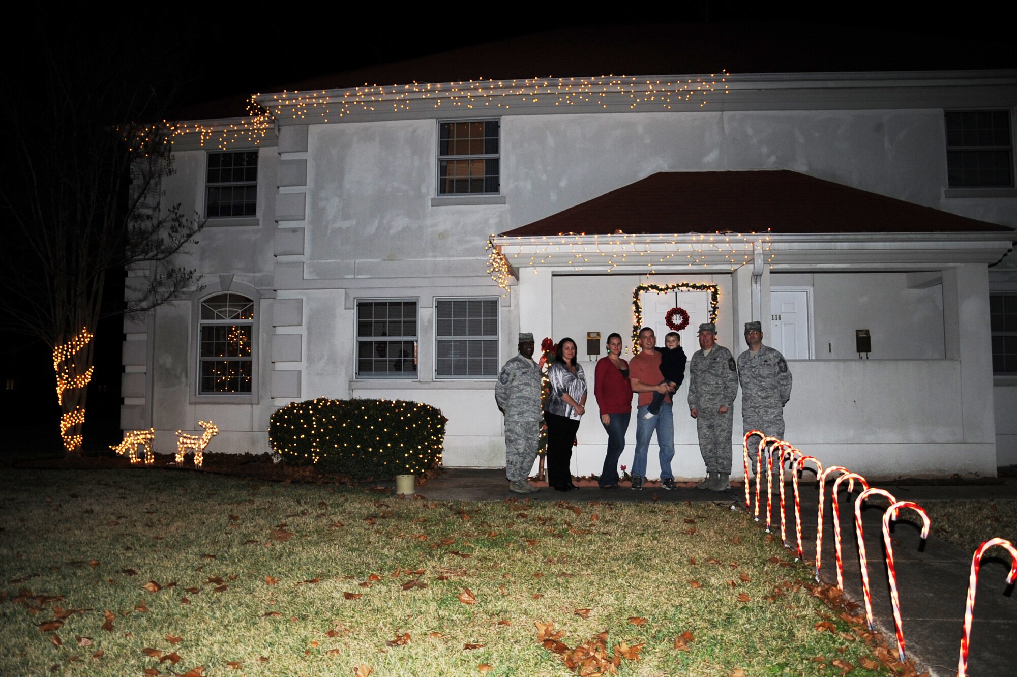 A winner of the holiday lighting contest poses with members of the Barksdale Chief's Group and a representative from the housing office during the Holiday Lights Contest on Barksdale Air Force Base, La., Dec. 18. Four houses were chosen as having the best holiday decorations and were presented with a $100 gift card. (U.S. Air Force photo/Senior Airman Sean Martin)