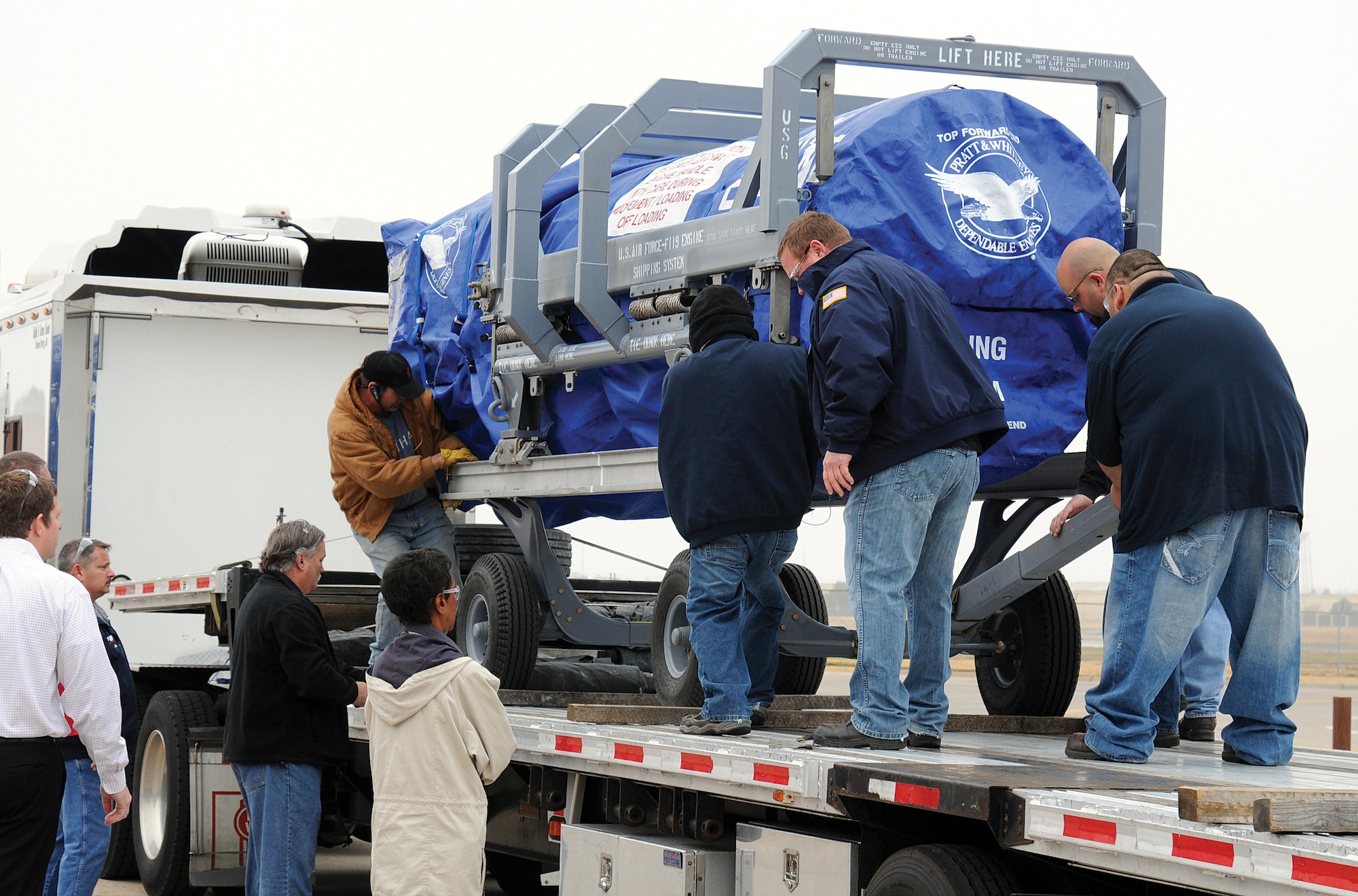 With careful precision, an F119 engine is secured on a flatbed trailer Dec. 7 outside the Oklahoma City Air Logistics Complex after a successful project test run. The detailed testing prepares the OC-ALC to produce engines in the F119 Heavy Maintenance Center operated here with Pratt & Whitney. (Air Force photo by Margo Wright)