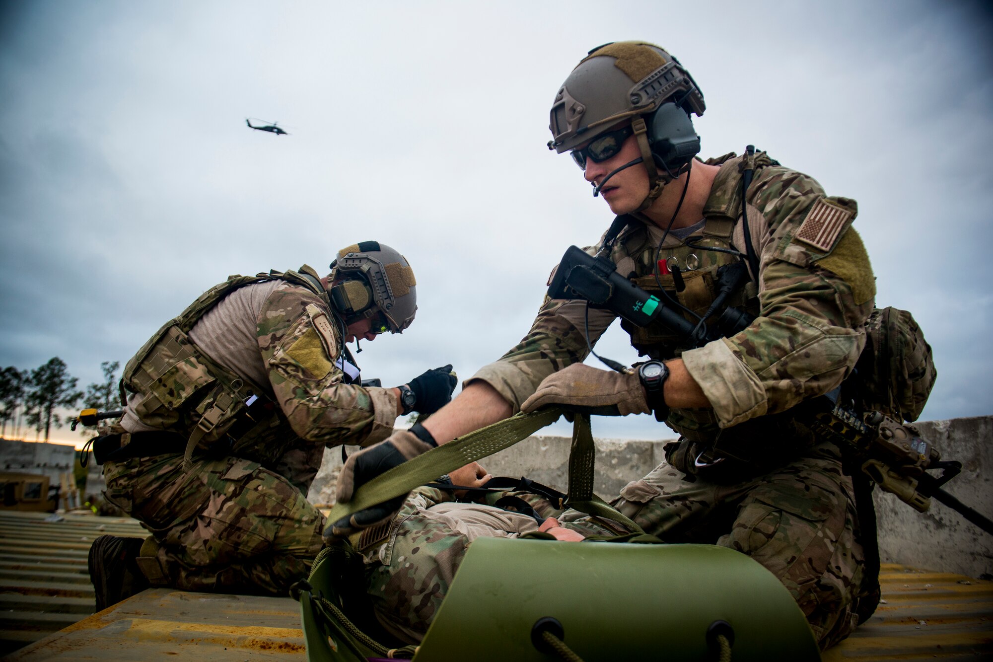 U.S. Air Force Staff Sgts. Eric Braddock, left, and Ryan Onely, both 38th Rescue Squadron pararescuemen, prepare Capt. Nicholas Morgans, 38th RQS combat rescue officer, for a medical evacuation during a training mission at Avon Park Air Force Range, Fla., Dec. 13, 2012. An aircrew flying an HH-60G Pave Hawk helicopter helped extract the Airmen. (U.S. Air Force photo by Staff Sgt. Jamal D. Sutter/Released)