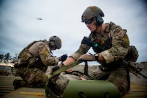 U.S. Air Force Staff Sgts. Eric Braddock, left, and Ryan Onely, both 38th Rescue Squadron pararescuemen, prepare Capt. Nicholas Morgans, 38th RQS combat rescue officer, for a medical evacuation during a training mission at Avon Park Air Force Range, Fla., Dec. 13, 2012. An aircrew flying an HH-60G Pave Hawk helicopter helped extract the Airmen. (U.S. Air Force photo by Staff Sgt. Jamal D. Sutter/Released)