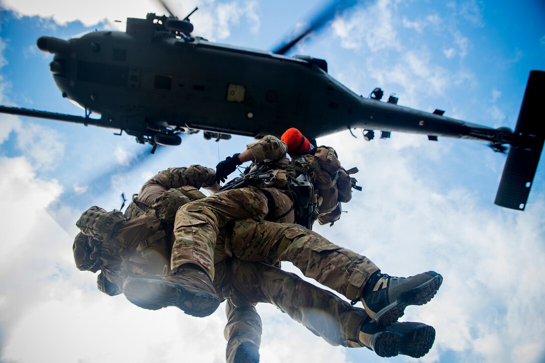 U.S. Air Force 2nd Lt. Kendrick Passey and Staff Sgt. Craig Patterson, both assigned to the 38th Rescue Squadron, gets hoisted to an HH-60 Pave Hawk helicopter during a training mission at Avon Park Air Force Range, Fla., Dec. 12, 2012. The Airmen took part in a medical evacuation where they assisted members of the 823d Base Defense Squadron after an ambush. (U.S. Air Force photo by Staff Sgt. Jamal D. Sutter/Released)