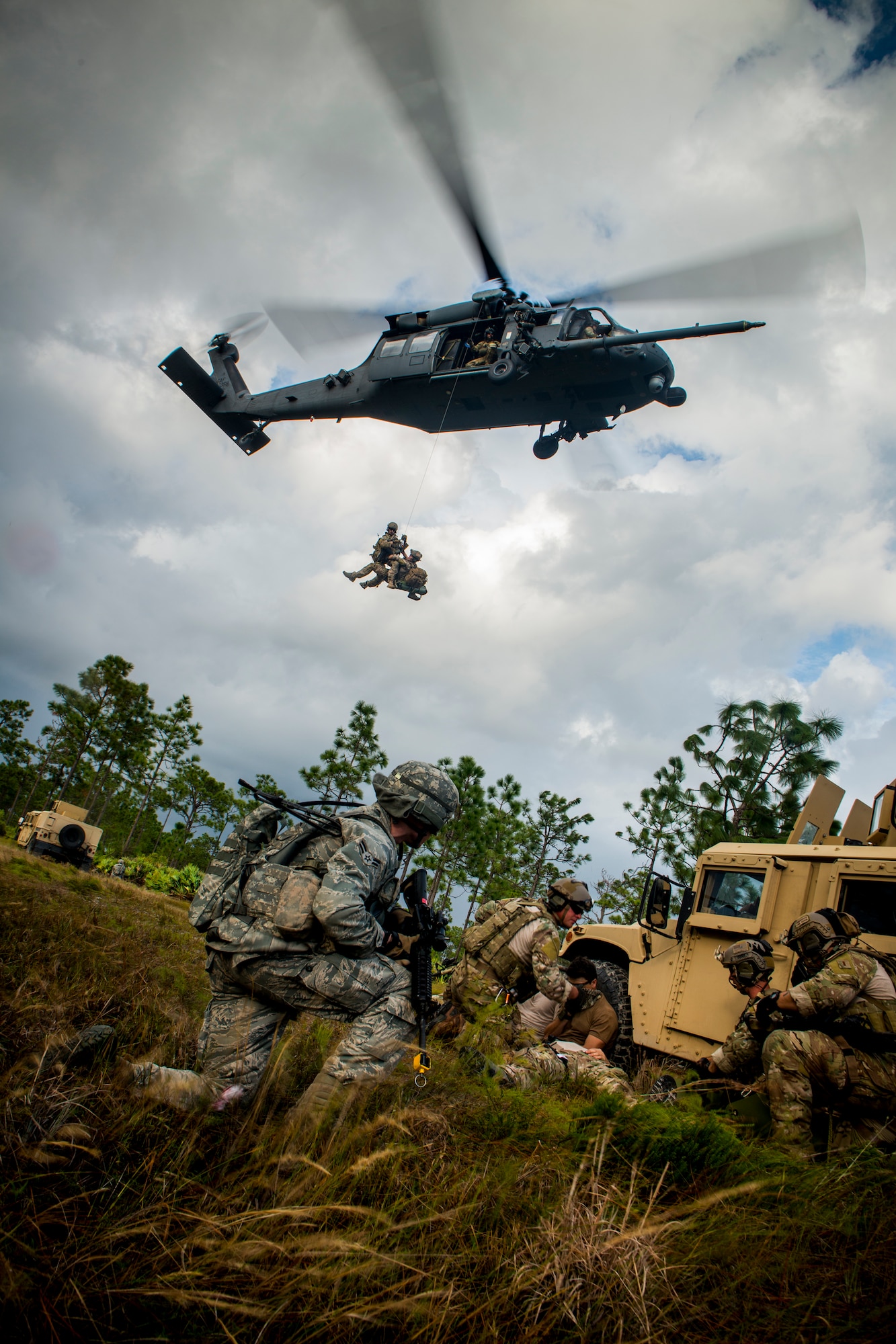 Airmen from the 823d Base Defense Squadron and 38th Rescue Squadron ground themselves as an HH-60G Pave Hawk from the 41st Rescue Squadron hovers above them during a medical evacuation at Avon Park Air Force Range, Fla., Dec. 12, 2012. The evacuation was part of a three-day training exercise testing their ability to operate during hostile situations. (U.S. Air Force photo by Staff Sgt. Jamal D. Sutter/Released) 
