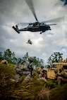 Airmen from the 823d Base Defense Squadron and 38th Rescue Squadron ground themselves as an HH-60G Pave Hawk from the 41st Rescue Squadron hovers above them during a medical evacuation at Avon Park Air Force Range, Fla., Dec. 12, 2012. The evacuation was part of a three-day training exercise testing their ability to operate during hostile situations. (U.S. Air Force photo by Staff Sgt. Jamal D. Sutter/Released) 