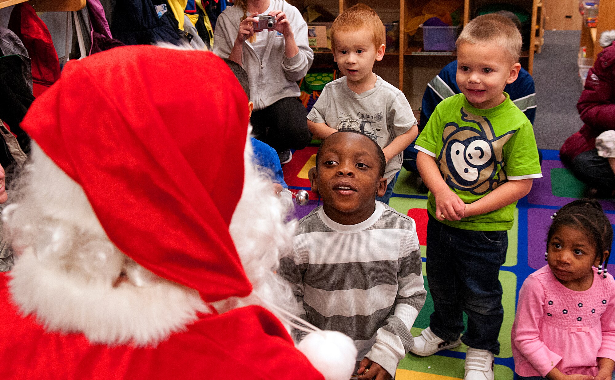 James Thomas, center, and his preschool classmates Mason Mecklenberg, Shawn Fisher and Cheyenne Vaden, visit with Santa who stopped by their classroom at the F. E. Warren Air Force Base Child Development Center Dec. 14. Santa made his rounds through the center visiting children, handing out small toys and hearing requests for Christmas morning. (U.S. Air Force photo by R.J. Oriez)