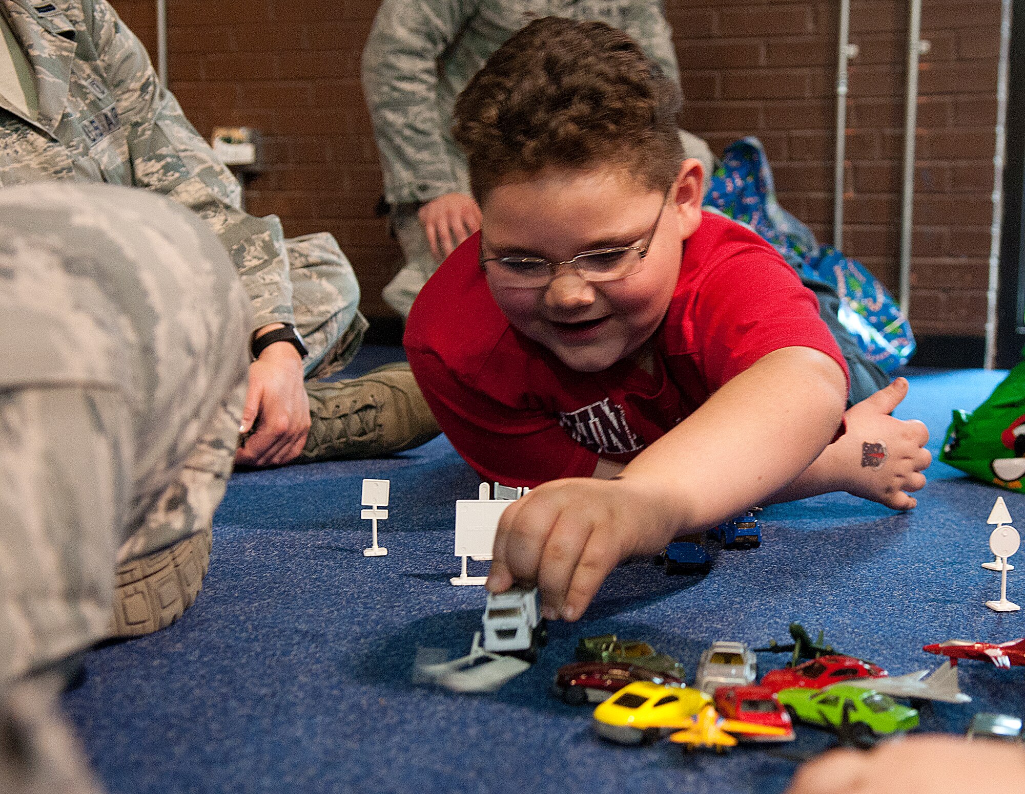 Paul Ingels, 7, plays with a toy-car set he got from Santa at Operation Provide Joy, in the Fall Hall Community Center, Dec. 15. The annual event gives local children a chance to spend time with F. E. Warren Airmen playing games, visiting with Santa and opening presents. Airman 1st Class Ian Holmberg, 90th Security Forces Group was Woolington’s escort. (U.S. Air Force photo by R.J. Oriez) 