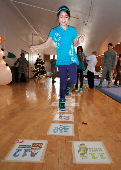 Alicia Munguia, 10, plays hopscotch in the Fall Hall Community Center during Operation Provide Joy Dec. 15. The annual event gives local children a chance to spend time with F. E. Warren Airmen playing games, visiting with Santa and opening presents. (U.S. Air Force photo by R.J. Oriez) 