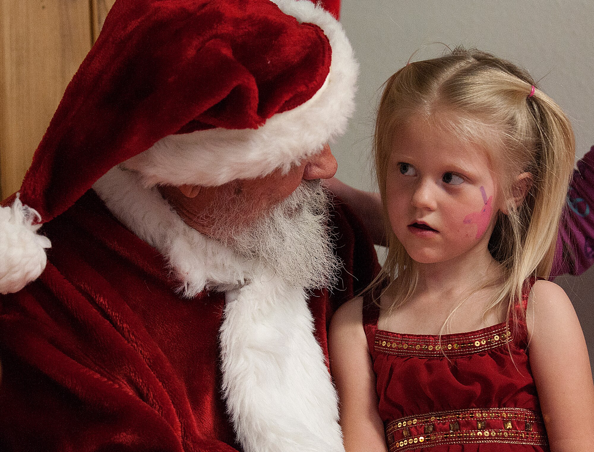 Lynzee Smith, 5, tells Santa what she wants for Christmas while visiting with him during Operation Provide Joy, at the Fall Hall Community Center Dec. 15. (U.S. Air Force photo by R.J. Oriez)