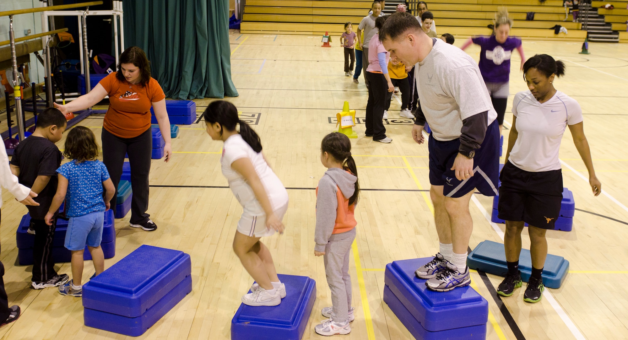 ROYAL AIR FORCE LAKENHEATH, England - Children and volunteers participate in a Kids on the Move class at the Lakenheath Elementary School Gym Dec. 13, 2012. KOTM is a free program intended to help children become more active and change their approach to exercise. The program is offered year-round and is open to children ages 4 - 12. Children older than 12 are welcome to participate as volunteers, helpers or team leaders. (U.S. Air Force photo Staff Sgt. Stephen Linch)