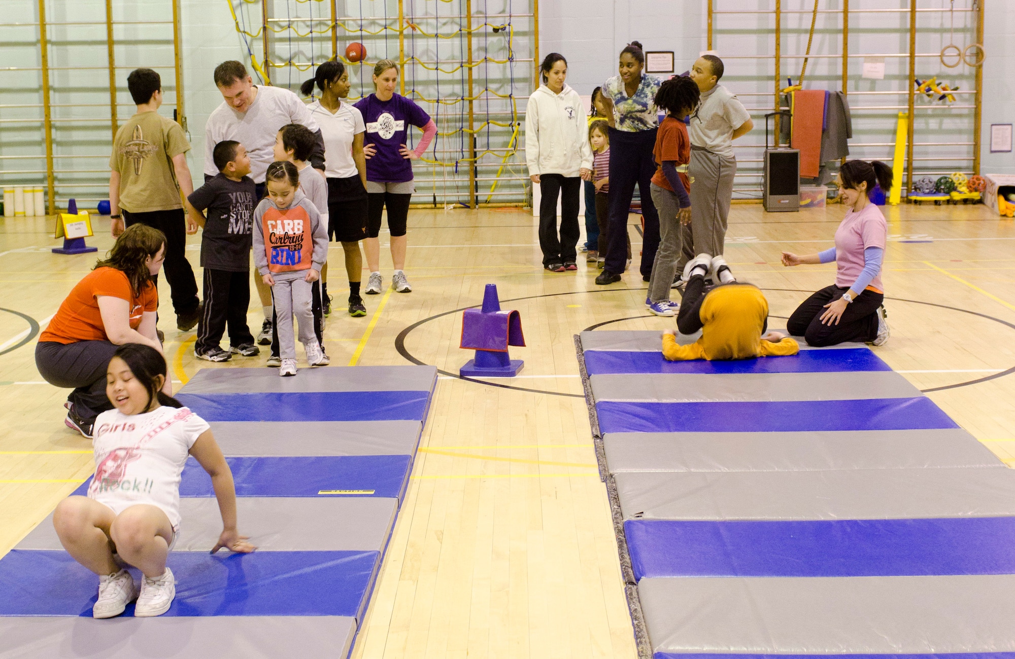 ROYAL AIR FORCE LAKENHEATH, England - Children and volunteers participate in a Kids on the Move class at the Lakenheath Elementary School Gym Dec. 13, 2012. The RAF Lakenheath Health and Wellness Center developed KOTM to help children become more active and change their approach to exercise. Each class consists of a high-intensity-interval-training workout, a game and a cool-down session. (U.S. Air Force photo Staff Sgt. Stephen Linch)
