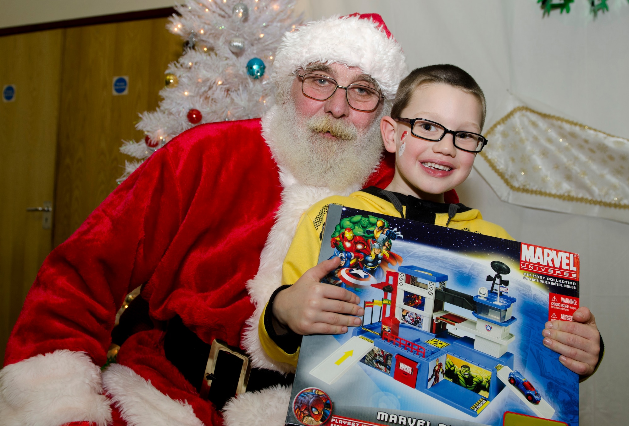 MILDENHALL, England - Dillon, 5, poses with Santa Claus, a North Pole native, and his present, during the 48th Equipment Maintenance Squadron Annual Christmas Party, which was held for U.K. children at the Jubilee Center Dec. 17, 2012. Approximately 80 children received presents, which were donated by members of the 48th EMS and 48th Maintenance Operations Squadron. (U.S. Air Force photo by Staff Sgt. Stephen Linch)
