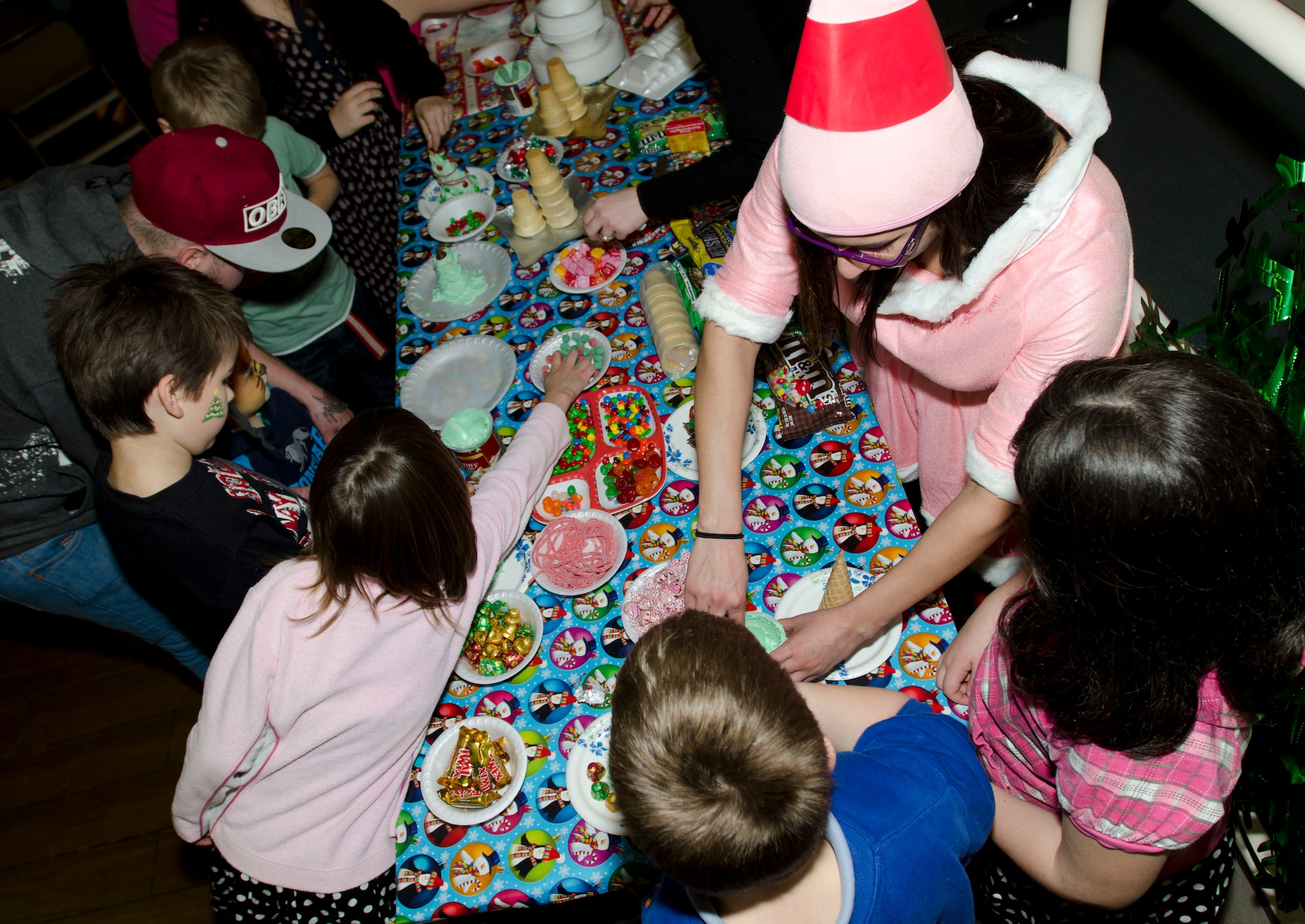 MILDENHALL, England - Senior Airman Cecille Finch (center right), 48th Maintenance Operation Squadron engine time change monitor and Christmas party elf, helps children put together candy Christmas trees during the 48th Equipment Maintenance Squadron Annual Christmas Party, which was held for U.K. children, at the Jubilee Center Dec. 17, 2012. The event, which 48th EMS Airmen have been putting on for 15 years, maintains traditions stemming from World War II when Americans would hold parties and give gifts to local children. (U.S. Air Force photo by Staff Sgt. Stephen Linch)