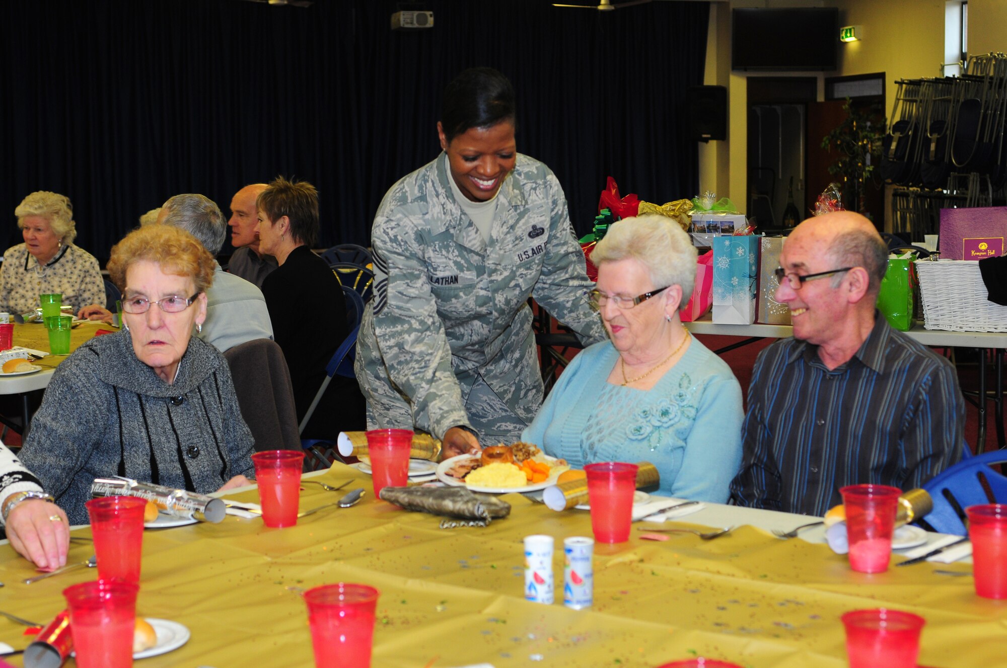 ROYAL AIR FORCE LAKENHEATH, England – Chief Master Sgt. Sarita L. Lathan, 48th Fighter Wing command chief, serves a plate of food to Pamela Peck, of Mildenhall Village, during a Christmas lunch hosted by the 48th Security Forces Squadron Dec. 19, 2012. More than 40 members of the local community attended the luncheon which included games, prizes and holiday gifts donated by Liberty Wing Airmen. (U.S. Air Force photo by Airman 1st Class Cory D. Payne)