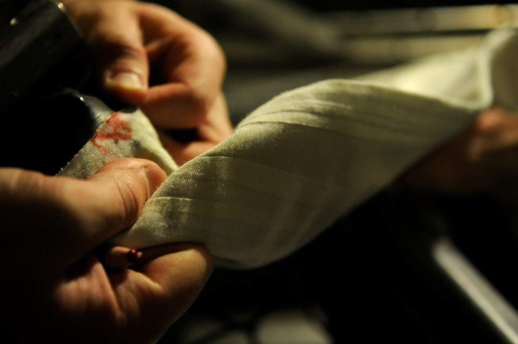 Senior Airman Joshua Stewart, 8th Operations Support Squadron aircrew flight equipment technician, shows the proper way to mark a tear found on an anti-exposure suit during water testing Dec. 11, 2012, at Kunsan Air Base, Republic of Korea. When any damage is found on the suit, AFE technicians sew and repair it with seam tape before re-testing and certifying it as safe for a pilot to wear.  (U.S. Air Force photo by Senior Airman Brigitte N. Brantley/Released)