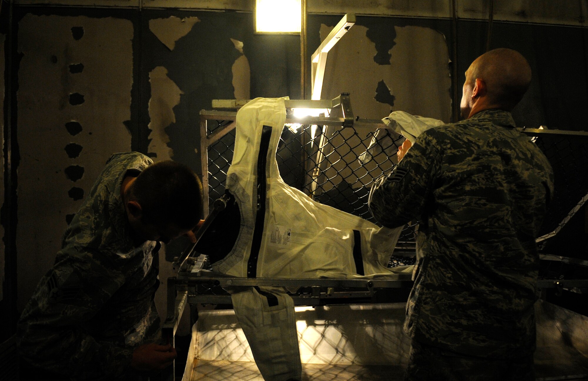 Senior Airman Joshua Stewart, left, 8th Operations Support Squadron aircrew flight equipment technician, double-checks that the neck seal on an anti-exposure suit is properly clamped as Staff Sgt. Joshua Smith, 8th OSS AFE assistant NCO in charge, helps Dec. 11, 2012, at Kunsan Air Base, Republic of Korea. The suits, which have an average shelf life of 10 years, are tested regularly for mission readiness. (U.S. Air Force photo by Senior Airman Brigitte N. Brantley/Released)