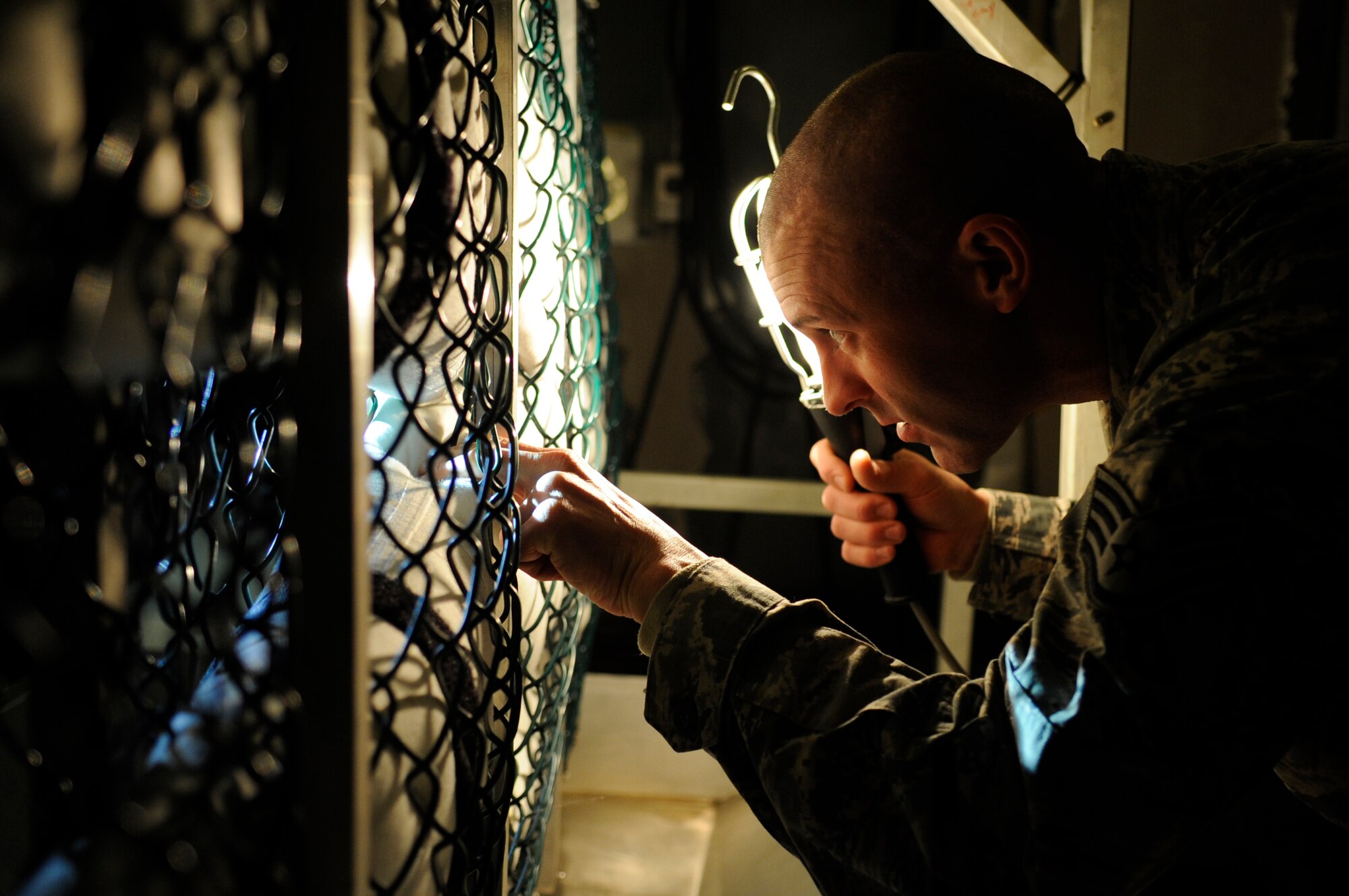 Staff Sgt. Joshua Smith, 8th Operations Support Squadron aircrew flight equipment assistant NCO in charge, inspects an anti-exposure suit for any tears or abrasions Dec. 11, 2012, at Kunsan Air Base, Republic of Korea. AFE technicians ensure these suits are airtight and waterproof to increase a pilot’s chances of survival if he must eject over water. (U.S. Air Force photo by Senior Airman Brigitte N. Brantley/Released)