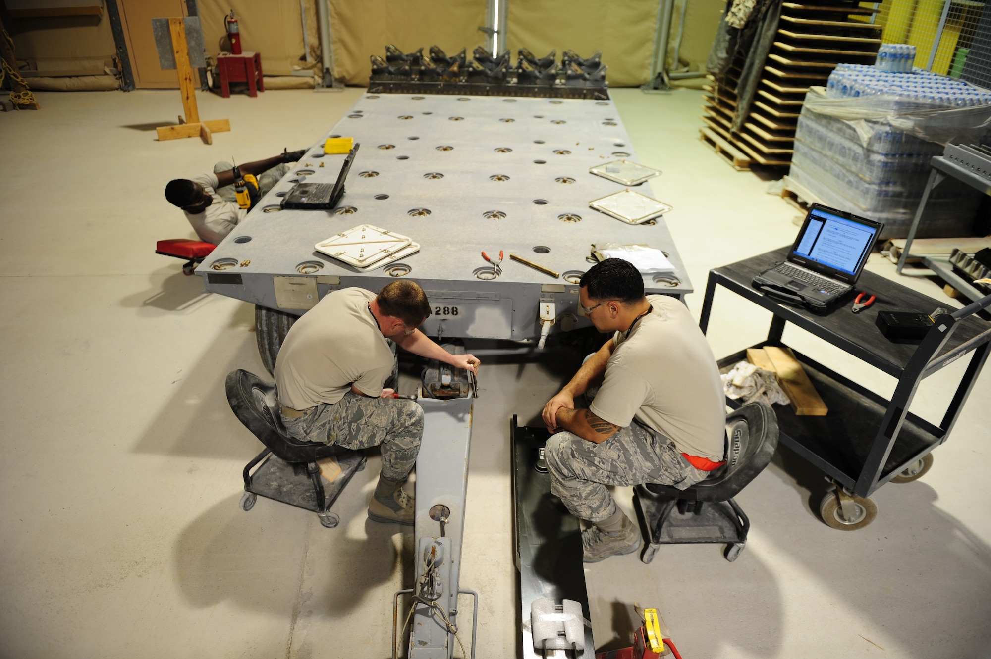 SOUTHWEST ASIA -- Members of the 379th Expeditionary Maintenance Squadron Munitions Support Equipment shop, refit an ammunitions trailer Dec. 19. The refit includes a lighter tow bar, replacing the current two-person lift tow bar, and placing warning placards around the side of the trailer. The placards will identify hazards when munitions are loaded on the trailer. (U.S. Air Force photo/Master Sgt Brendan Kavanaugh)