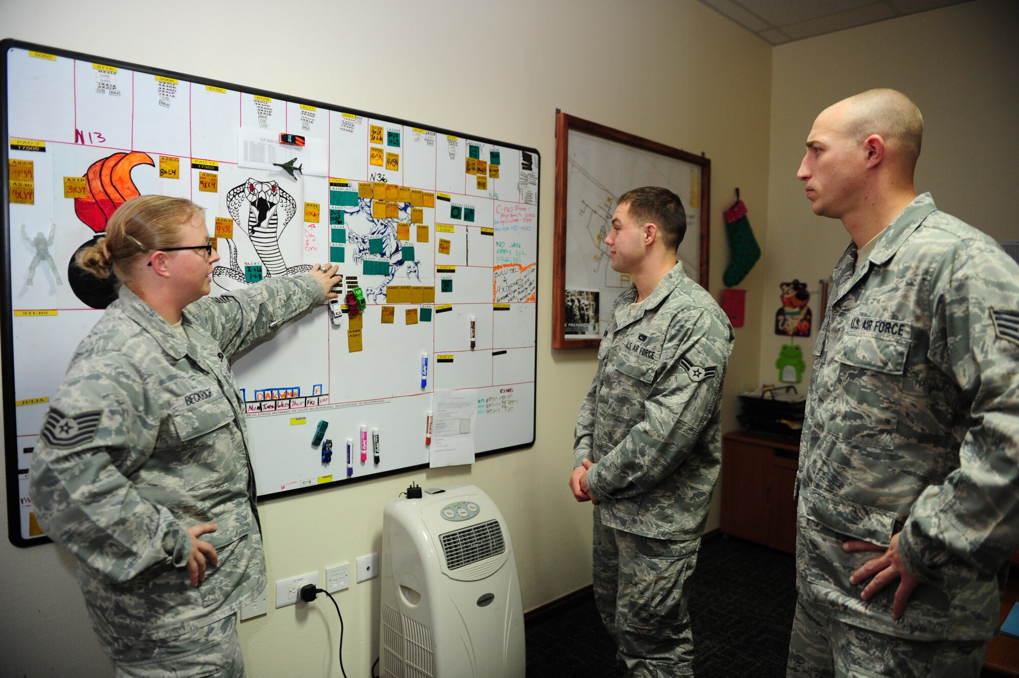 SOUTHWEST ASIA -- Tech. Sgt. Asha Beckrich, 379th Expeditionary Maintenance Squadron Munitions Control section, discusses daily operations with members of her section Dec. 19. Munitions control is responsible for coordinating all munitions storage, movement and loading, with B-1B crew chiefs, air crews and maintainers. Munition control also works with coalition partners as well as the Navy, Army and Marine Corps to provide courtesy storage for various weapon systems. (U.S. Air Force photo/Master Sgt Brendan Kavanaugh)