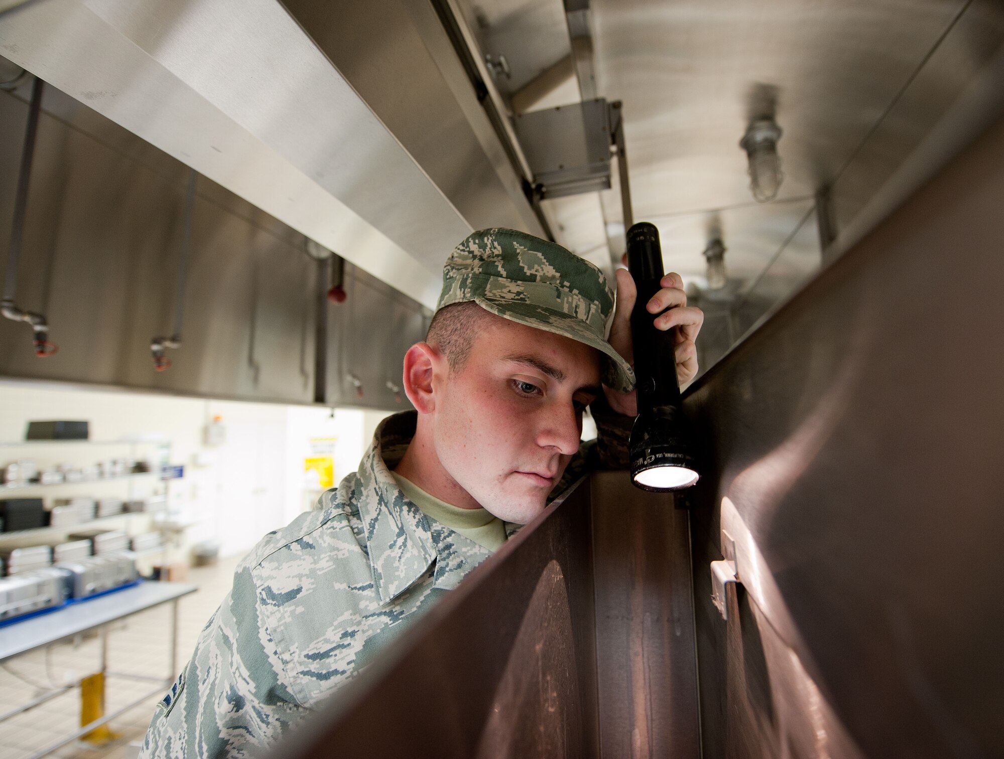 YOKOTA AIR BASE, Japan -- Senior Airman Alex Brown, 374th Civil Engineer Squadron Pest Management technician, inspects equipment at the 374th Medical Group’s dining facility Dec. 19, 2012, at Yokota Air Base, Japan. During inspections, the pest management team looks for any recent insect activity and also set traps. (U.S. Air Force photo by Airman 1st Class John D. Partlow)