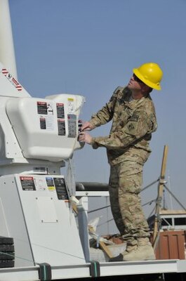 Staff Sgt. Daniel McKinney demonstrates the use of a utility truck's hydraulic system for Afghan electrical engineers and linemen during utility truck training held in early December, in Helmand province, Afghanistan. McKinney, assigned to the U.S. Army Corps of Engineers Prime Power Battalion in Kandahar, Afghanistan, was the lead instructor.