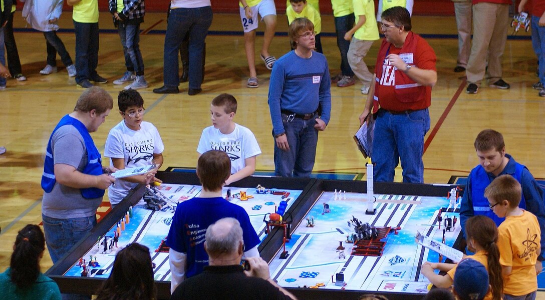 Two robotics teams compete head-to-head with the autonomous LEGO MINDSTORM robots they programmed to perform specific functions as the judges watch. The teams were competing in the Tulsa FIRST LEGO League qualifying event Nov. 10 at Memorial High School. The robots carry out the functions on a 4 by 8 foot surface. The FIRST LEGO League is a robotics program designed to get children excited about science and technology while teaching them employment and life skills.