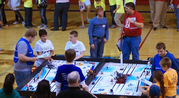 Two robotics teams compete head-to-head with the autonomous LEGO MINDSTORM robots they programmed to perform specific functions as the judges watch. The teams were competing in the Tulsa FIRST LEGO League qualifying event Nov. 10 at Memorial High School. The robots carry out the functions on a 4 by 8 foot surface. The FIRST LEGO League is a robotics program designed to get children excited about science and technology while teaching them employment and life skills.