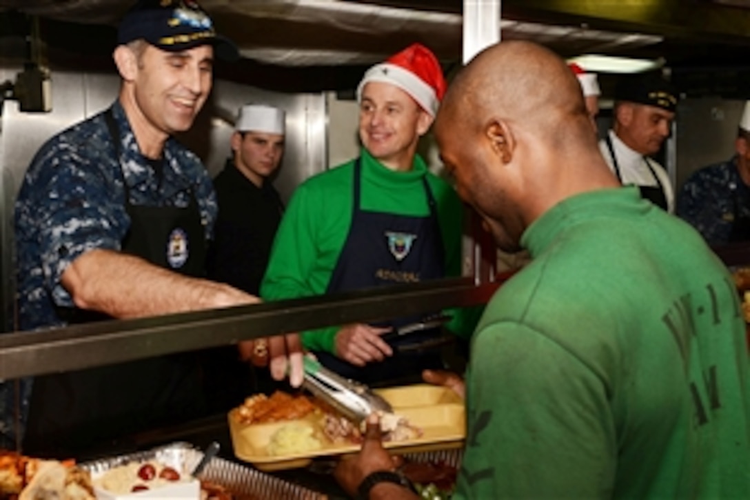 Navy Capt. Ronald Reis, left, commanding officer of the aircraft carrier the USS John C. Stennis, and Rear Adm. Mike Shoemaker, commander, Carrier Strike Group 3, serve ailors during a holiday meal in the Arabian Sea, Dec 19, 2012. The John C. Stennis is deployed to the U.S. 5th Fleet area of responsibility conducting maritime security and supporting Operation Enduring Freedom.