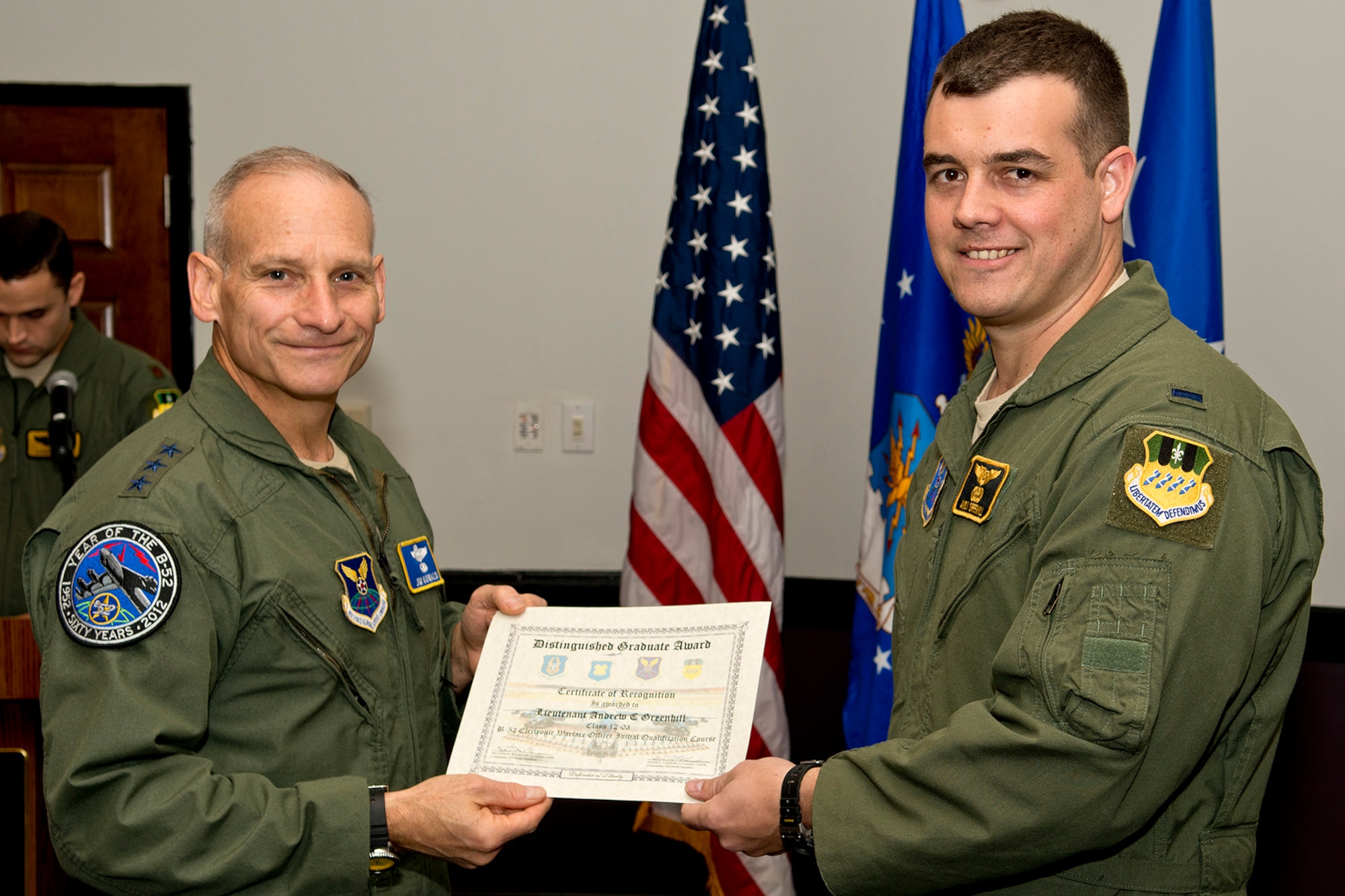 U.S. Air Force Lt. Gen. James Kowalski presents the Electronic Warfare Officer Distinguished Graduate award to 1st Lt. Andrew Greenhill during a B-52 Formal Training Unit Graduation ceremony, Dec. 21, 2012, Barksdale Air Force Base, La. The Distinguished Graduate Award is a culmination of academic tests, flight evaluations, officership, attitude and professional bearing, and the winner is selected by having demonstrated training and performance that was consistently and clearly above their peers. (U.S. Air Force photo by Master Sgt. Greg Steele/Released)