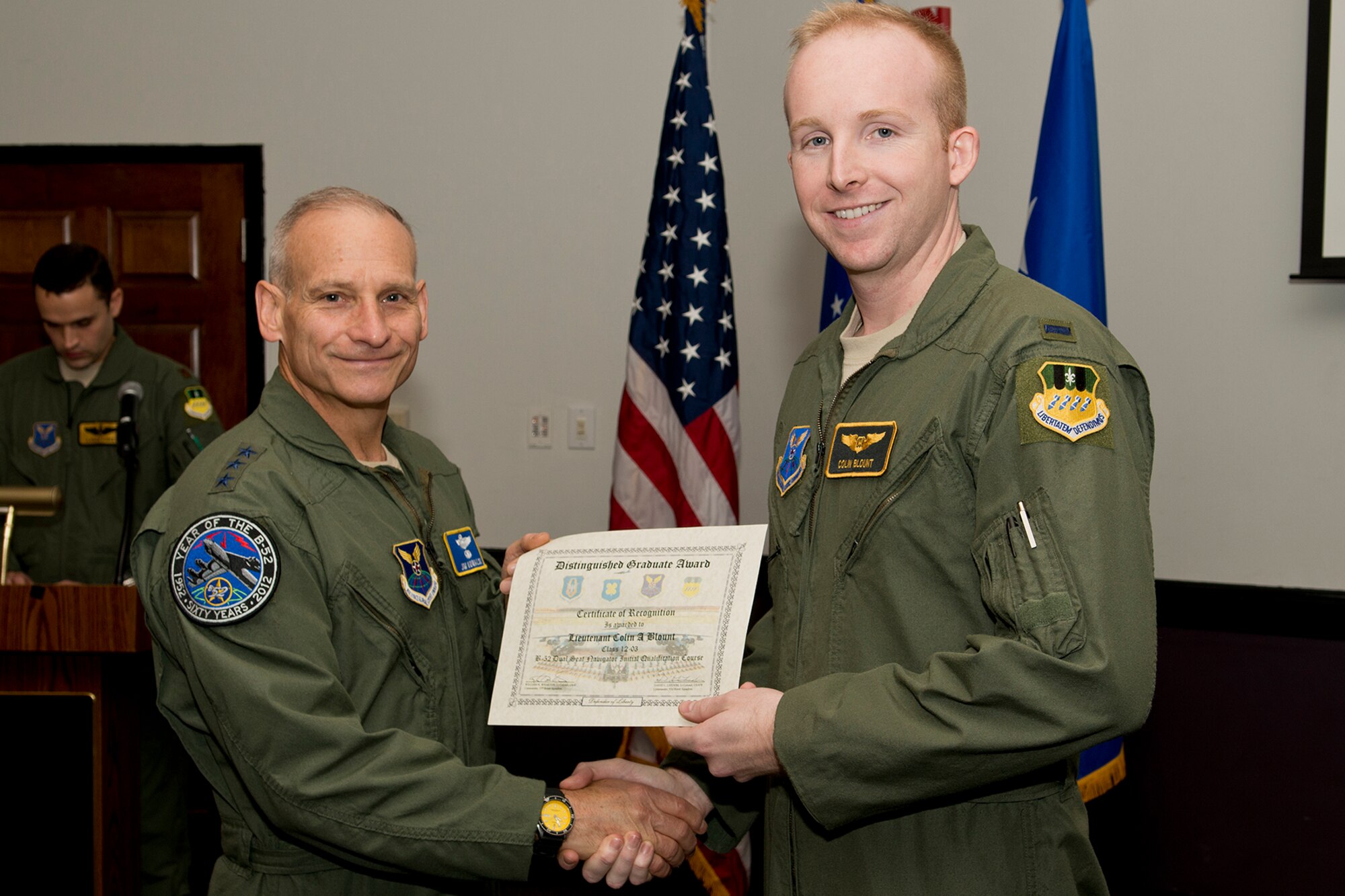 U.S. Air Force Lt. Gen. James Kowalski presents the Dual Seat Navigator Distinguished Graduate award to 1st Lt. Colin Blount during a B-52 Formal Training Unit Graduation ceremony, Dec. 21, 2012, Barksdale Air Force Base, La. The Distinguished Graduate Award is a culmination of academic tests, flight evaluations, officership, attitude and professional bearing, and the winner is selected by having demonstrated training and performance that was consistently and clearly above their peers. (U.S. Air Force photo by Master Sgt. Greg Steele/Released)