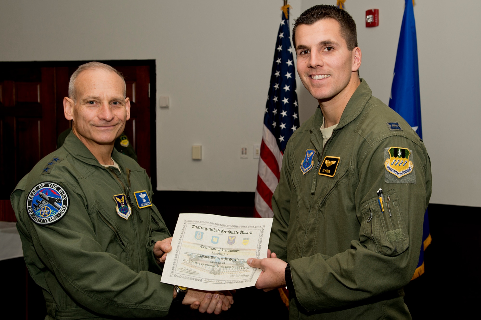U.S. Air Force Lt. Gen. James Kowalski presents the Aircraft Commander Distinguished Graduate award to Capt. William Harris during a B-52 Formal Training Unit Graduation ceremony, Dec. 21, 2012, Barksdale Air Force Base, La. The Distinguished Graduate Award is a culmination of academic tests, flight evaluations, officership, attitude and professional bearing, and the winner is selected by having demonstrated training and performance that was consistently and clearly above their peers. (U.S. Air Force photo by Master Sgt. Greg Steele/Released)